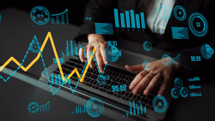 A business professional engaged in data analysis on a laptop with vibrant graphs and charts...