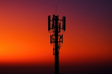 Silhouette of a cell tower against a vibrant sunset gradient.