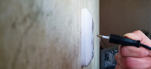 A woman includes an electrical appliance, plug into the socket. The use of household appliances,...