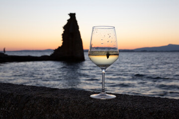 glass of Albariño wine with the San Sadurniño tower in the background. Sunset, Cambados