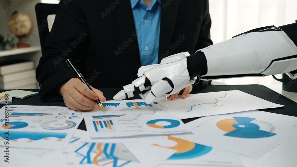 Poster a human collaborates with a robotic hand in an office, analyzing various graphs and charts to enhanc