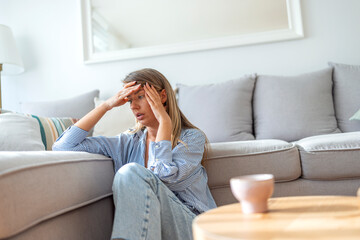 Worried Woman Sitting on the Floor in a Stylish Modern Living Room