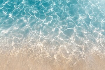 Clear turquoise water gently laps at sandy shore, creating a serene and tranquil beach scene with shimmering reflections and soft waves