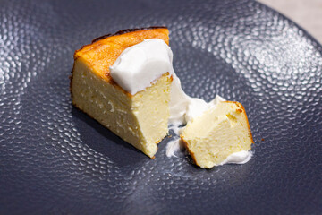 Delicious Slice of Cheesecake with Cream Topping on a Textured Plate