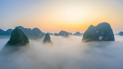 Misty mountain peaks emerge from fog at sunrise