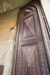 A wooden door with a lot of spikes on it in Bologna Italy