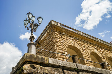 A street lamp is on a stone wall in Florence Italy Toscana