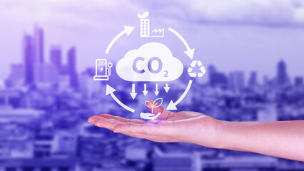 Hand holding CO2 reducing virtual icon for decrease carbon dioxide emission, carbon footprint and...