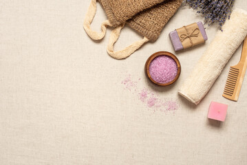 Bath accessories on beige linen background, top view, flat lay