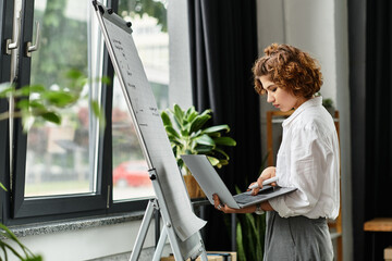 Businesswoman with curly hair focused on her laptop in a modern office setting