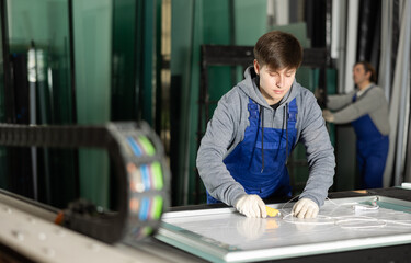 In workshop for production of glass products, guy co-worker cuts off excess from workpiece and...