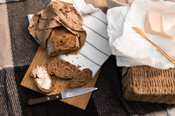 Close-up of autumn picnic elements — bread, butter, and woven textures evoke comfort and seasonal charm.