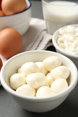 Different dairy products and eggs on grey wooden table, closeup