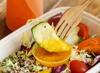 Roasted Pumpkin Salad with Zucchini, Quinoa and mixed greens in bowl closeup view of Healthy Lunch