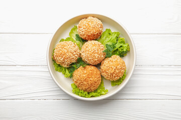 Delicious fried croquette balls with parsley and lettuce on white wooden table, top view