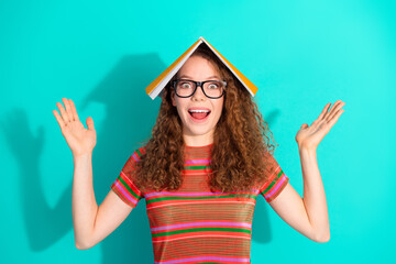 Playful young woman with curly hair and stylish outfit expressing happiness in front of a vibrant...