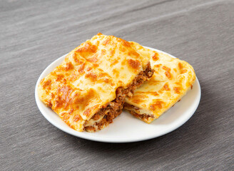 Golden Baked Beef Lasagna Slices on White Plate side view of Classic Italian Food