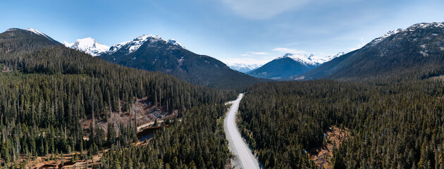 Scenic Mountain Valley Highway with Snowy Peaks and Dense Forests in British Columbia