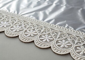 Obraz premium Intricate silver lace trim with floral patterns on a silky fabric