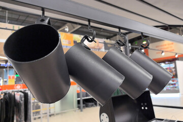 Modern metal mugs hanging in a trendy store display