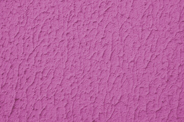 Close up of textured pink color painted wall with rough stucco, plaster wall texture. Vibrant background, wallpaper, backdrop, design element.