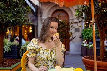 Woman savoring a delicious lemon dessert in a charming outdoor setting