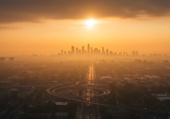Obraz premium Aerial view of a city skyline at sunset, golden hour, dramatic sky, with urban roads and architecture.
