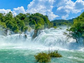Impressive front view of the powerful waterfalls in Krka National Park, Croatia. The strong water flow and lush surroundings highlight nature’s raw beauty and force.