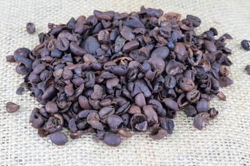 Roasted coffee beans on a burlap. Freshly roasted  aromatic strong dark brown coffee beans.