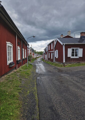 An alley lined with historic wooden houses painted red