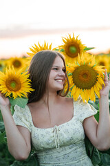 Smiling teenage girl in a field of sunflowers. Enjoying life.