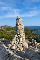 pile of rocks in front of kornati islands skyline in blue ocean, viewpoint veli vrh, Murter, Croatia