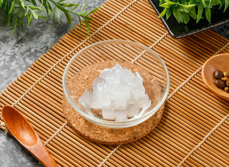 Translucent Coconut Jelly Cubes in Glass Bowl on Bamboo Mat side view of hong kong food