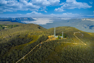 Drone aerial photograph of large communication towers on the ridge line of the picturesque and wide...