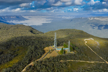 Drone aerial photograph of large communication towers on the ridge line of the picturesque and wide...