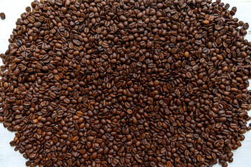 Closeup of roasted coffee beans background. High-resolution image of roasted coffee beans spread...