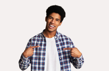 Charismatic black teen man promoting himself, pointing at body over white background