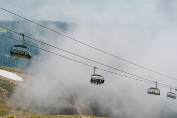 Cabs on the cable car stands against the backdrop of a summer forest and mountain peaks, Rosa...