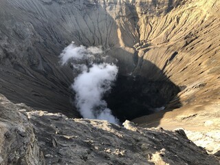 Active volcanic crater of Mount Bromo with steam rising from the depths, Indonesia