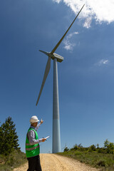 Worker with wind turbine in background
