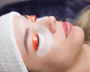 Caucasian woman undergoing eyelash lamination procedure. 
