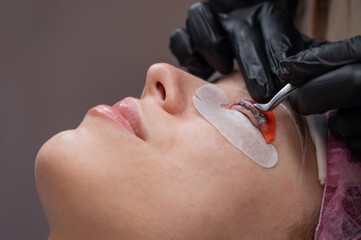 Caucasian woman undergoing eyelash lamination procedure. 