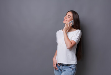 Modern lifestyle and communication. Smiling beautiful brunette girl talking on phone while standing...