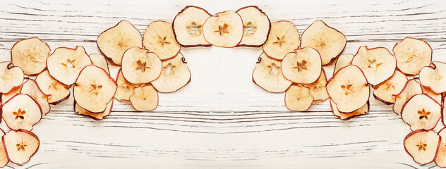 round dried apple chips on wooden background