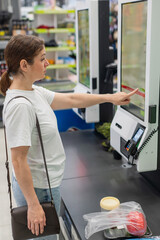 A woman scans items at a self-checkout. 