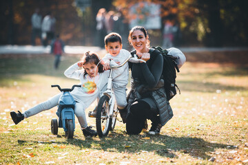 Mother and children enjoying a sunny day in the park with bikes