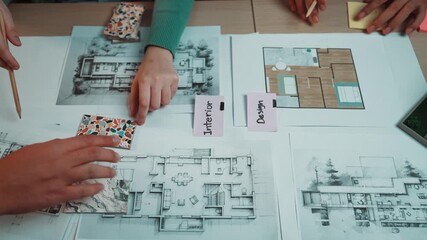 A creative workspace featuring detailed architectural blueprints and colorful design swatches. Hands at work illustrate the design planning process for modern interiors. SACTR - Powered by Adobe