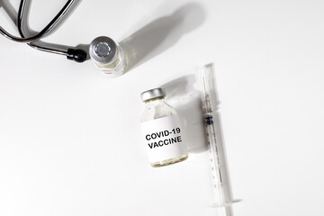 COVID-19 Vaccine Bottle with Syringe and Stethoscope on Desk – Pandemic Response and Global...