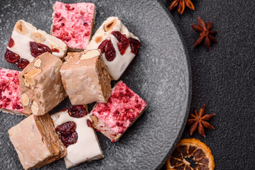 Nougat or white caramel with hazelnuts and pistachios and strawberry pieces. Nougat with nuts