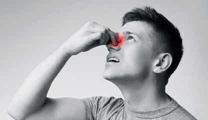 Haemophilia. Young man suffering from nose bleeding, black and white panorama